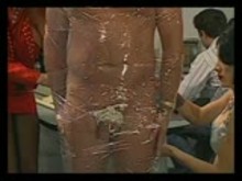 submissive male getting saran wrapped by group of Sexy Mistresses
